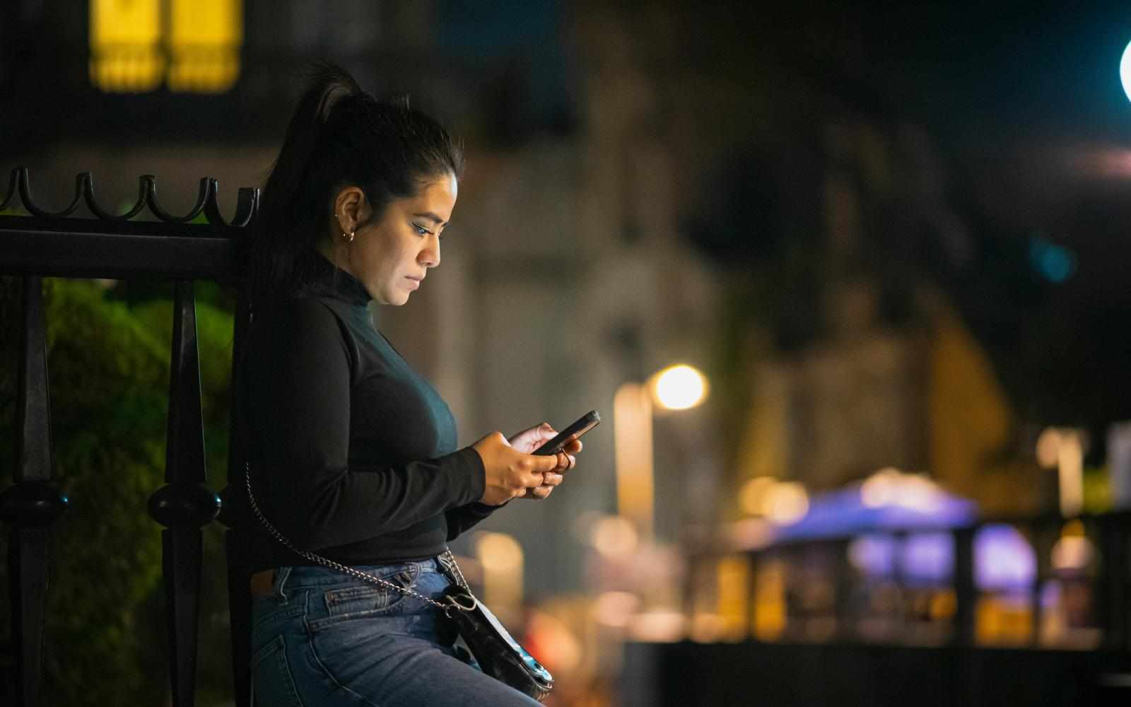 Joven mirando su celular en el metro